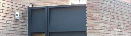 Una puerta negra está en el costado de un edificio de ladrillo.