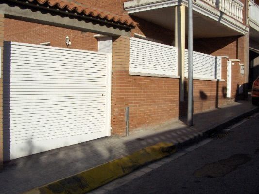 Un edificio de ladrillo con un coche aparcado delante.