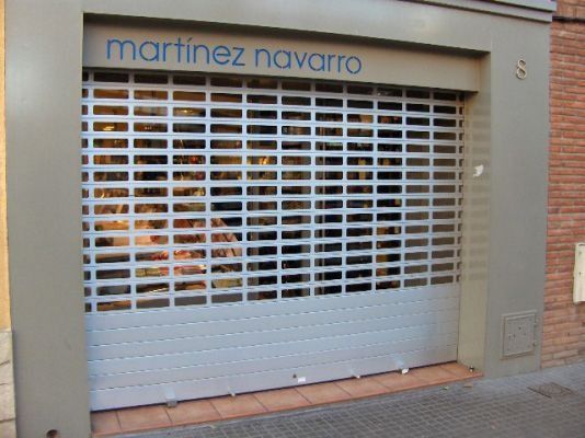 Un escaparate con una persiana que dice Martínez Navarro.