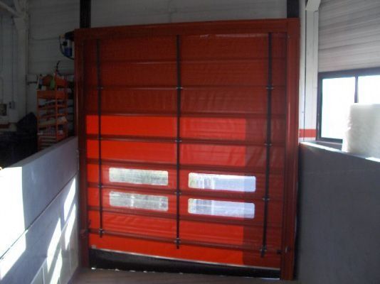 Una puerta roja está abierta en una habitación con una ventana.