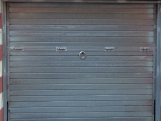 Un edificio con una puerta azul y una pared gris