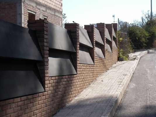 Una pared de ladrillos al costado de una carretera