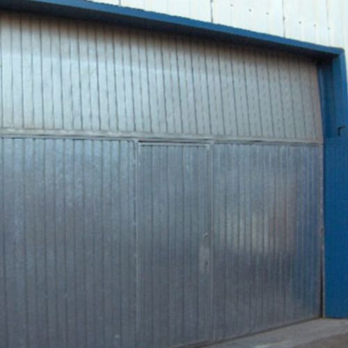 Un edificio con una puerta azul y una pared gris