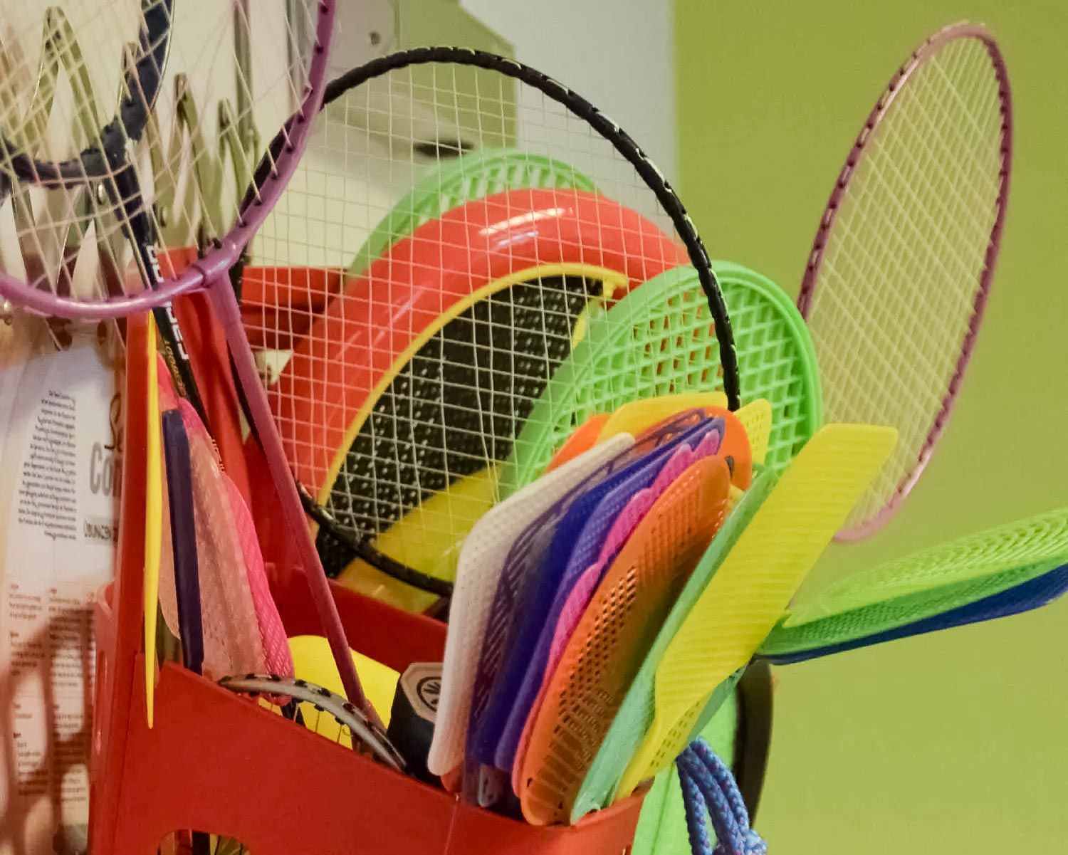 eine bunte Auswahl an Tennisschlägern hängt an einem Rack