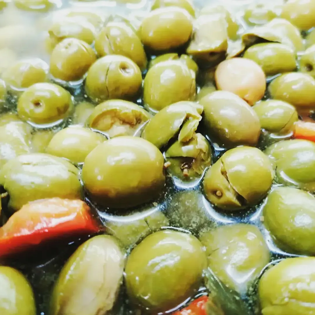Aceitunas verdes en salmuera con unos trozos de pimiento rojo.