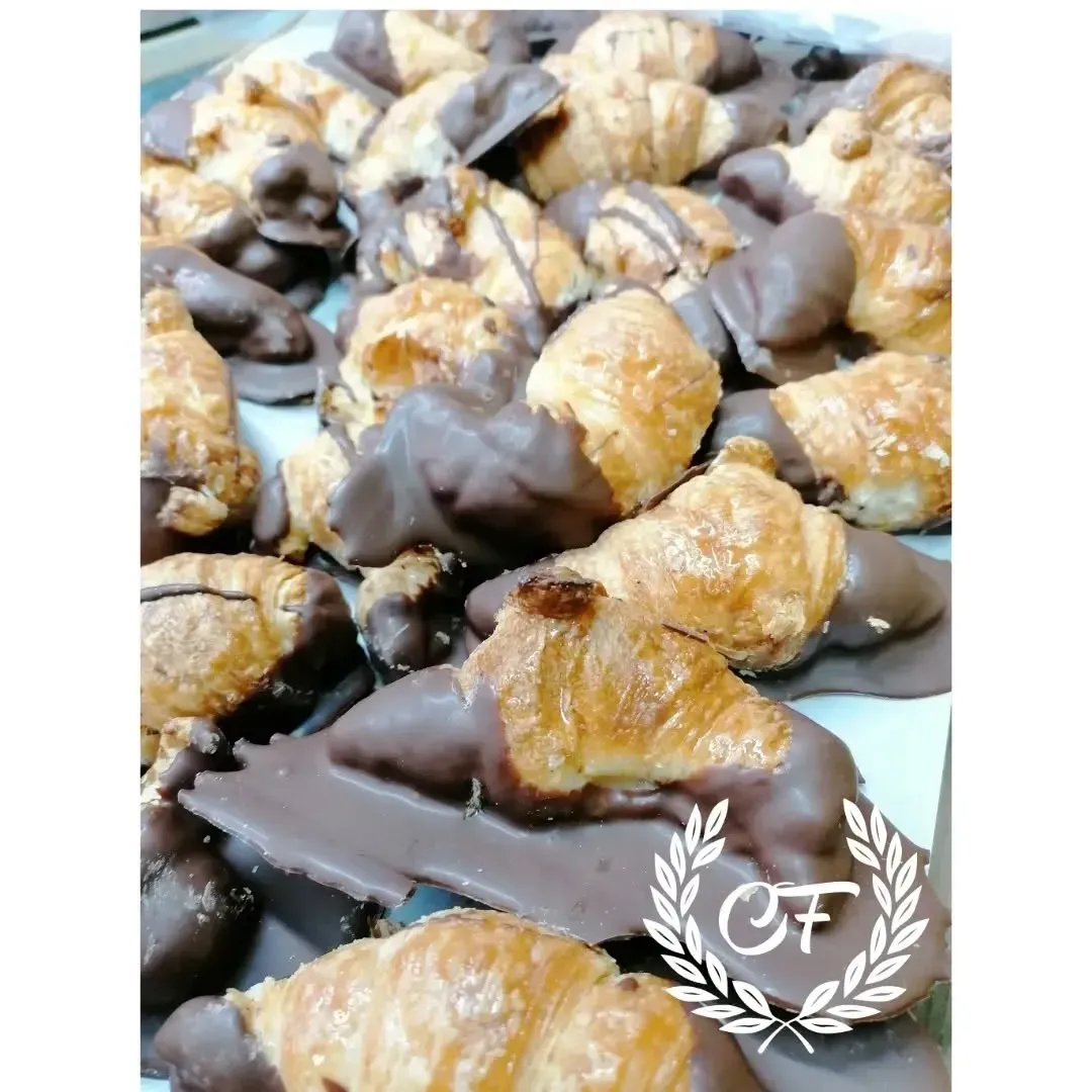 Mini croissants bañados en chocolate negro, bandeja de bollería.
