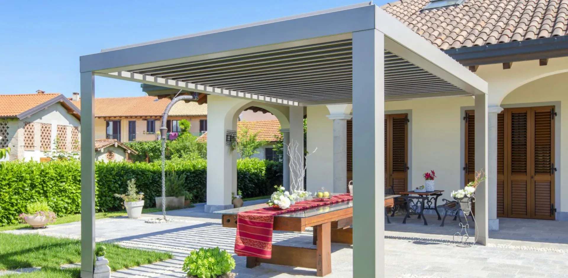 Pérgola bioclimática independiente creando una zona de comedor en el jardín en Boadilla del Monte