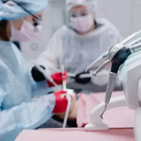 Un grupo de dentistas está trabajando con un paciente en un consultorio dental.