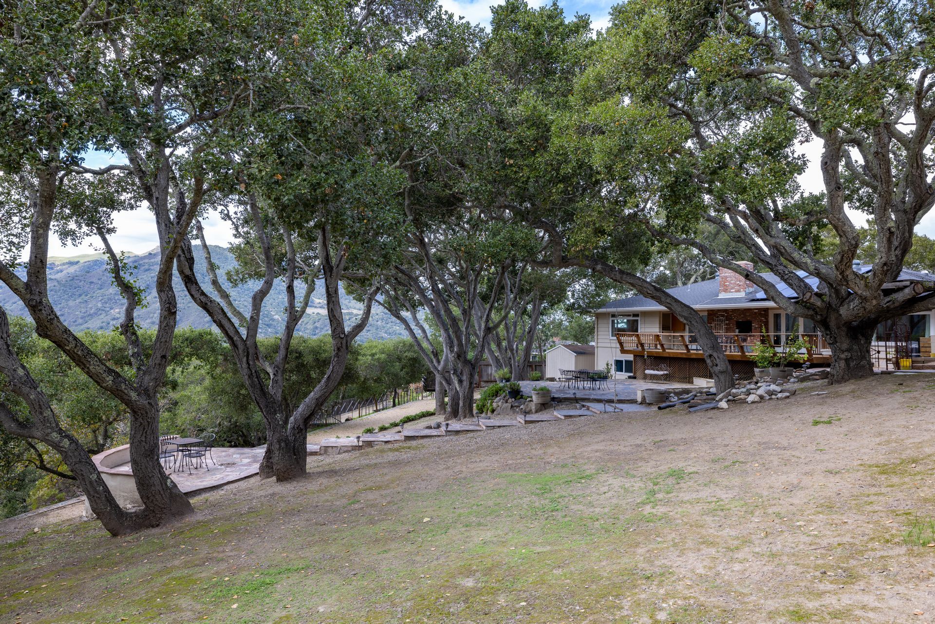A house is sitting on top of a hill surrounded by trees.