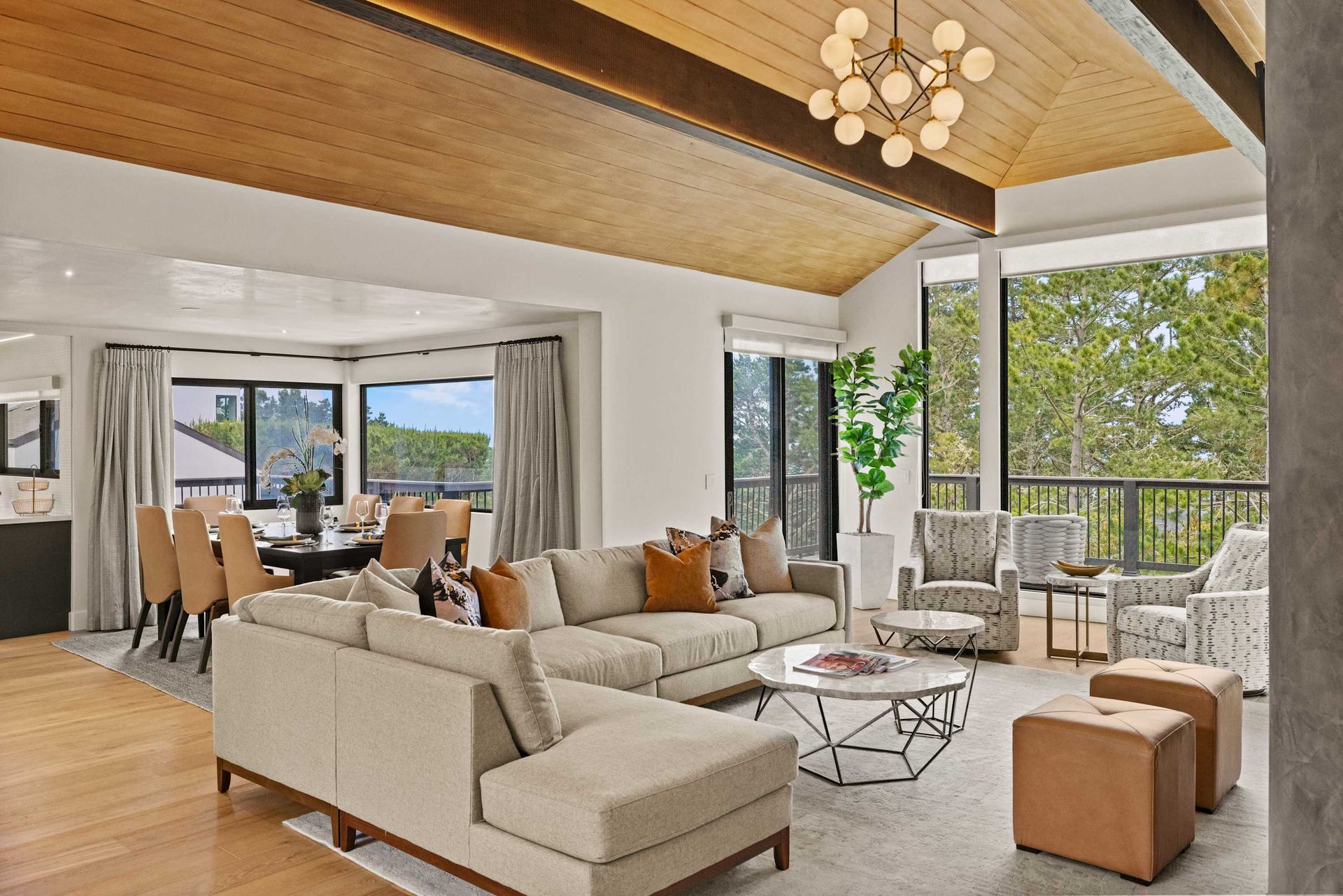 A luxury living room with a couch, chairs, ottomans and table.