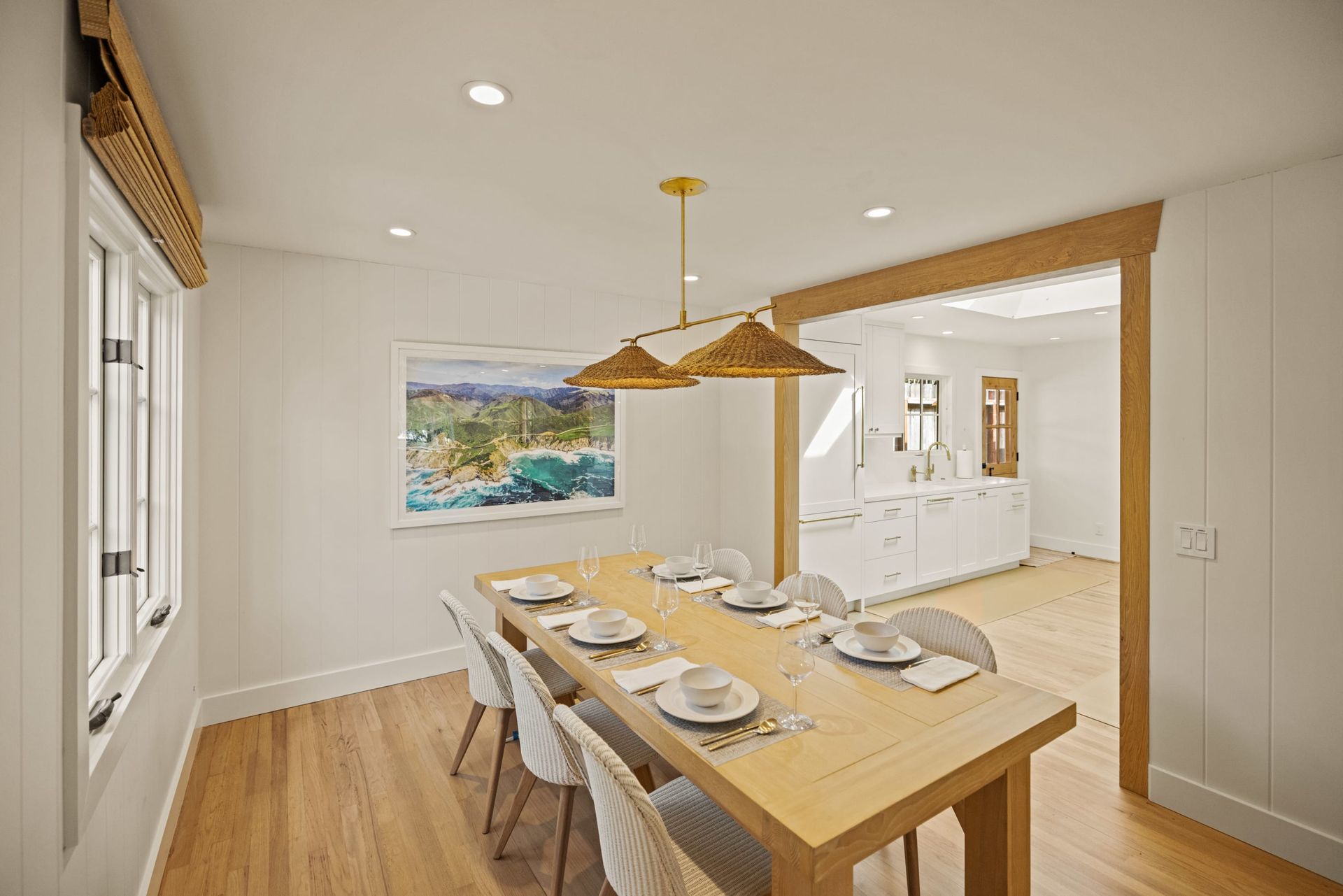 A dining room with a long wooden table and chairs.