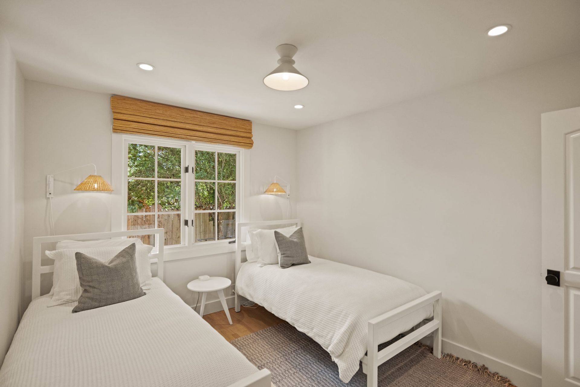 A bedroom with two twin beds and a window.