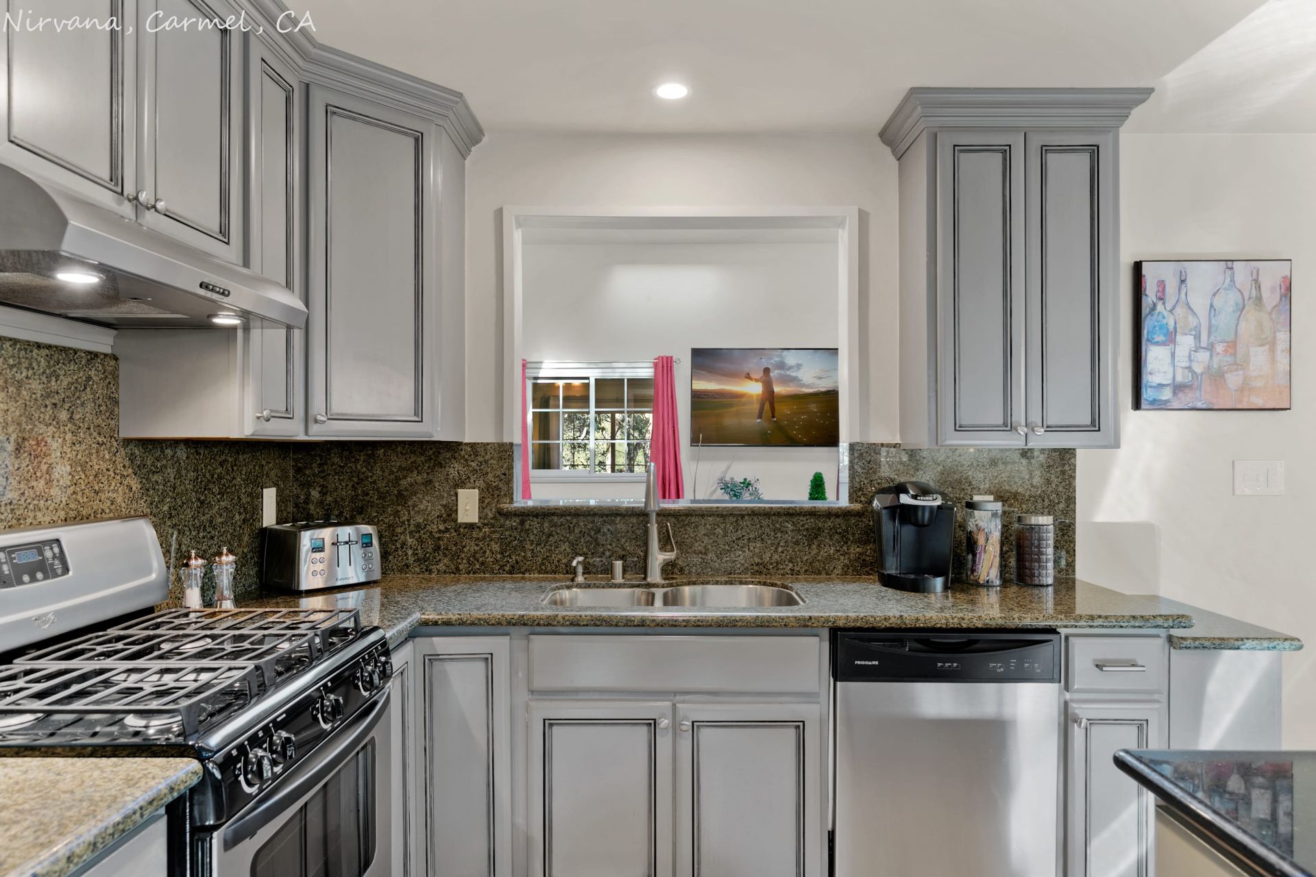 A kitchen with gray cabinets and stainless steel appliances