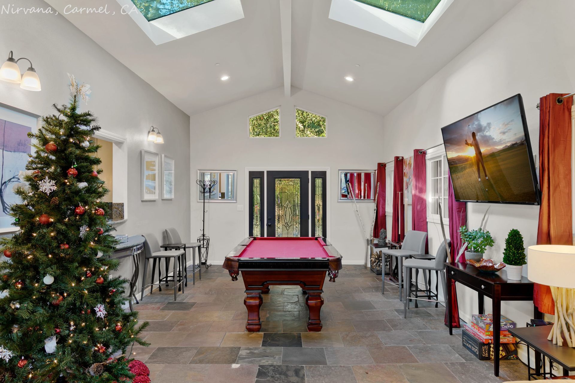 A pool table in a room with a christmas tree