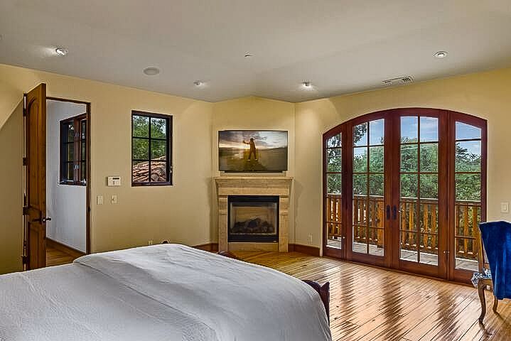 A bedroom with a fireplace and a large bed