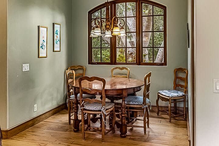A dining room with a table and chairs and a large window.