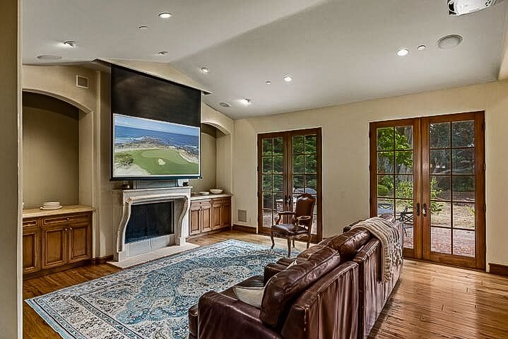 A living room with a couch , chair , fireplace and television.