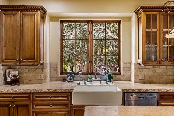 A kitchen with a sink , dishwasher , and window.