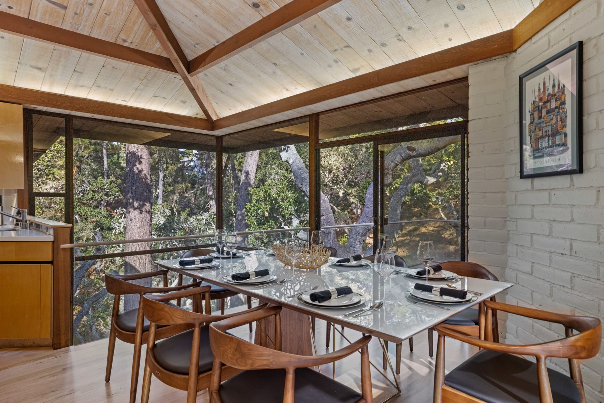 A dining room with a table and chairs and a large window.