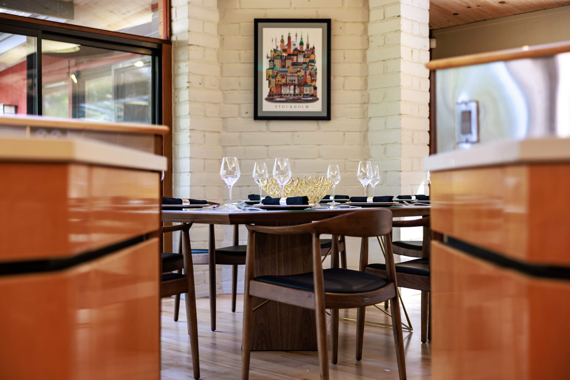 A dining room with a table and chairs and a picture on the wall.