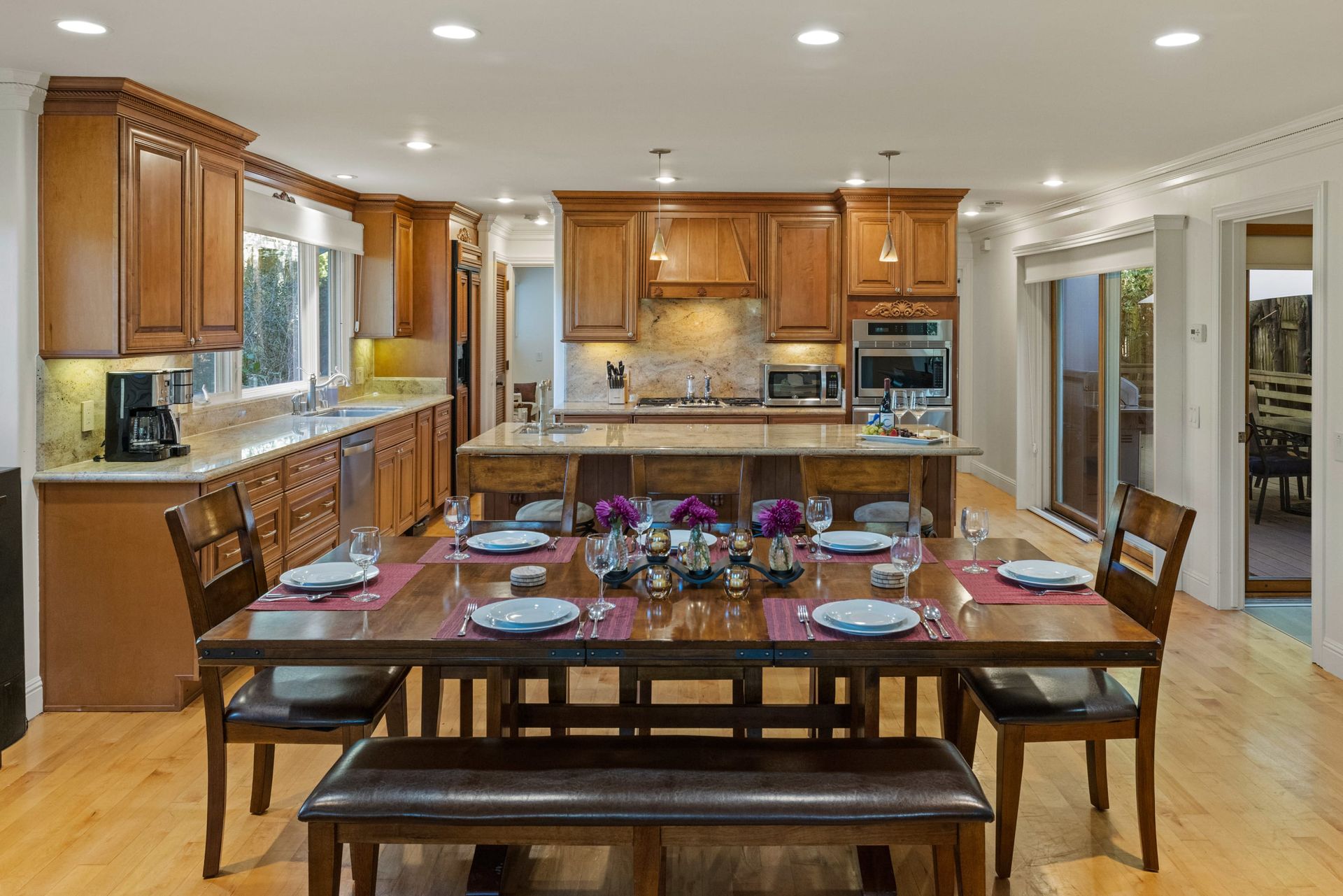 A kitchen and dining room with a large wooden table and chairs.