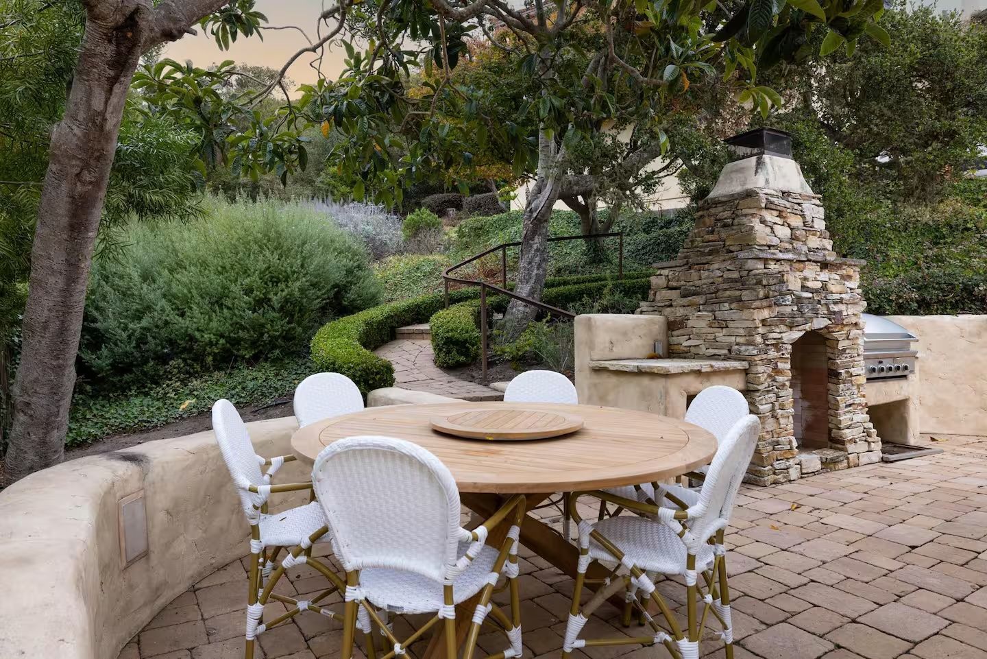 A patio with a table and chairs and a fireplace.