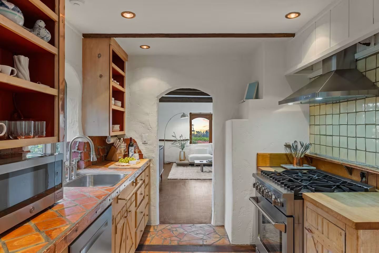 A kitchen with a stove , sink , and microwave.