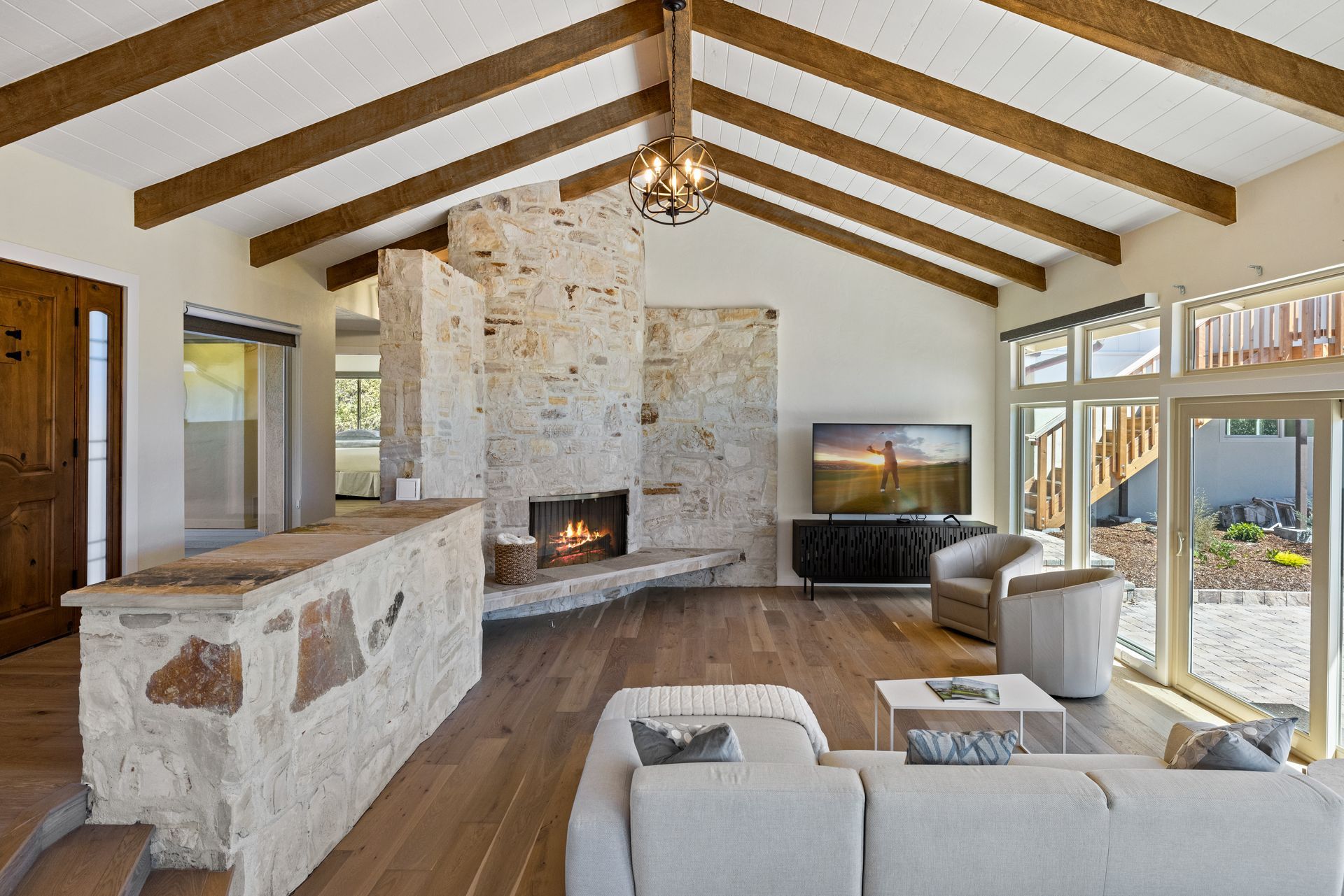 A living room with a couch , chairs , fireplace and television.