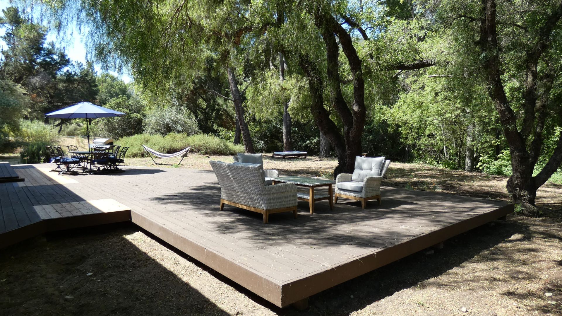 A wooden deck with a couch and chairs on it