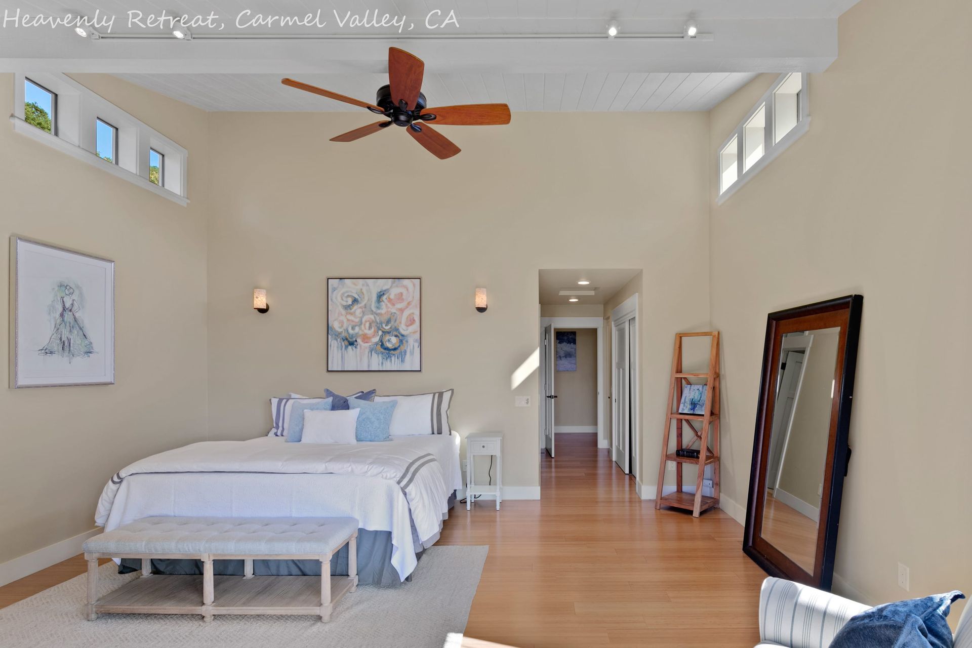 A bedroom with a large bed and a ceiling fan