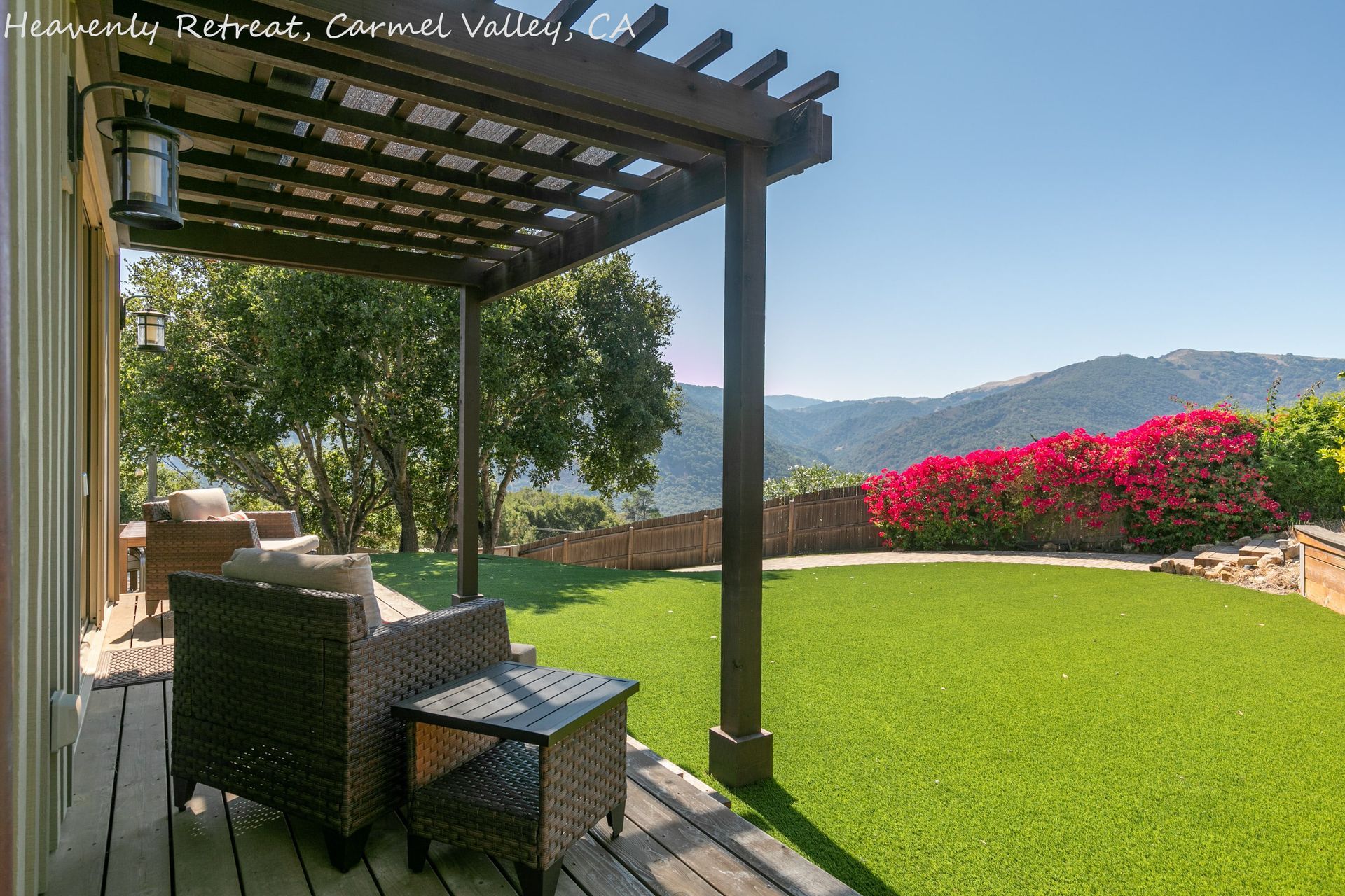 A deck with chairs and a table under a pergola