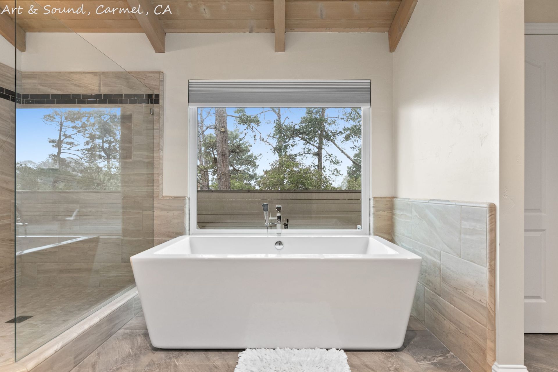 A bathroom with a large tub and a large window.