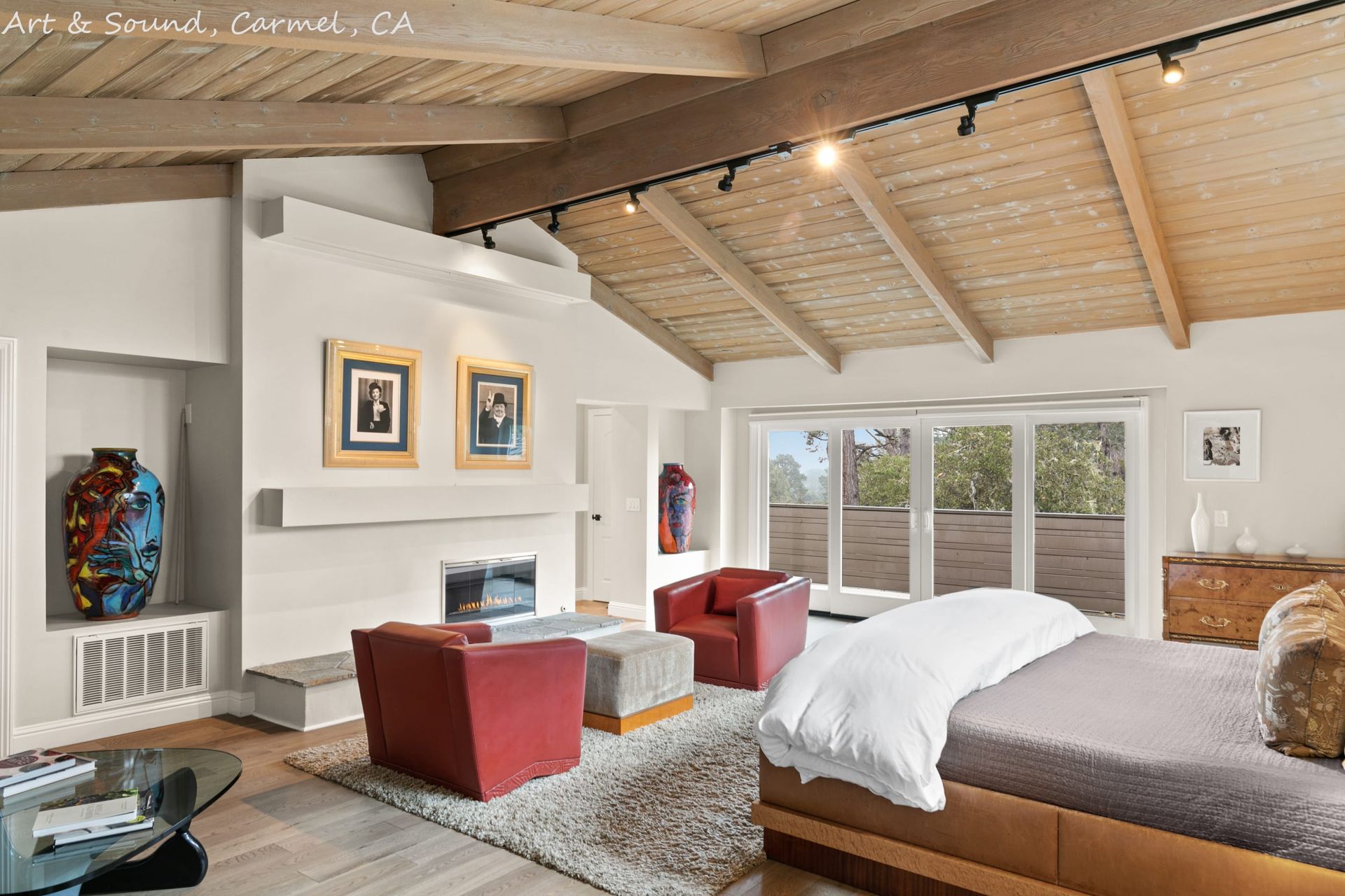 A bedroom with a bed , chairs and a fireplace