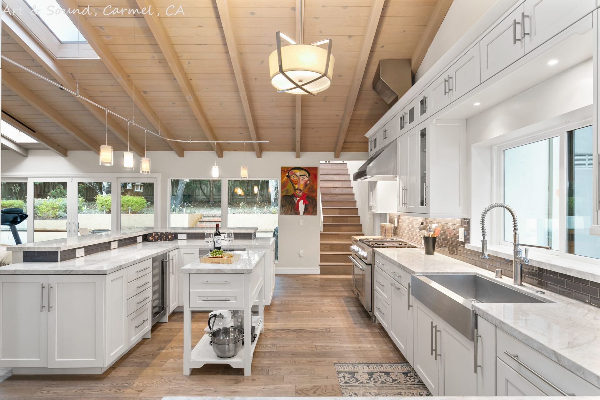 A kitchen with white cabinets and a stainless steel sink