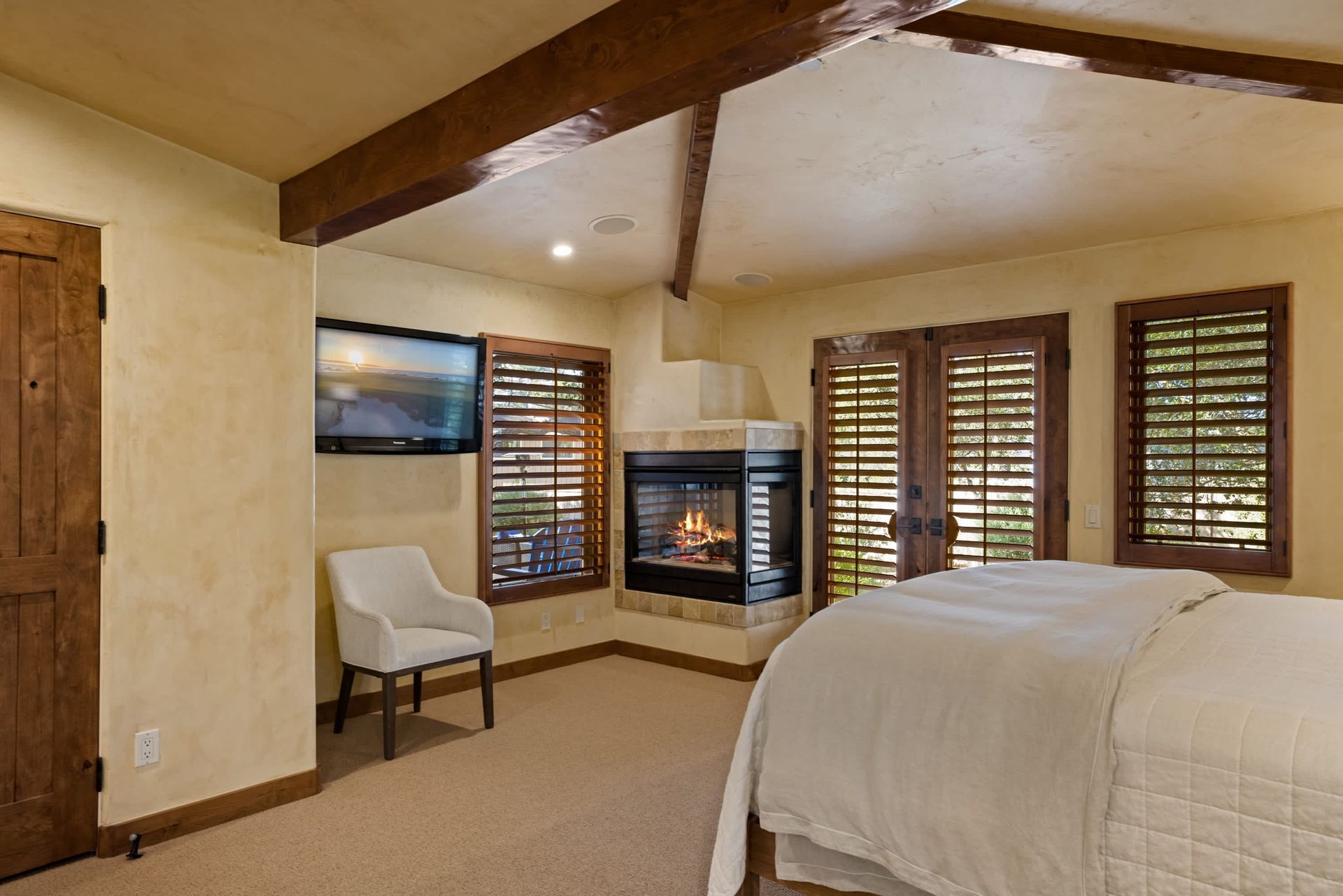 A bedroom with a fireplace and a large bed