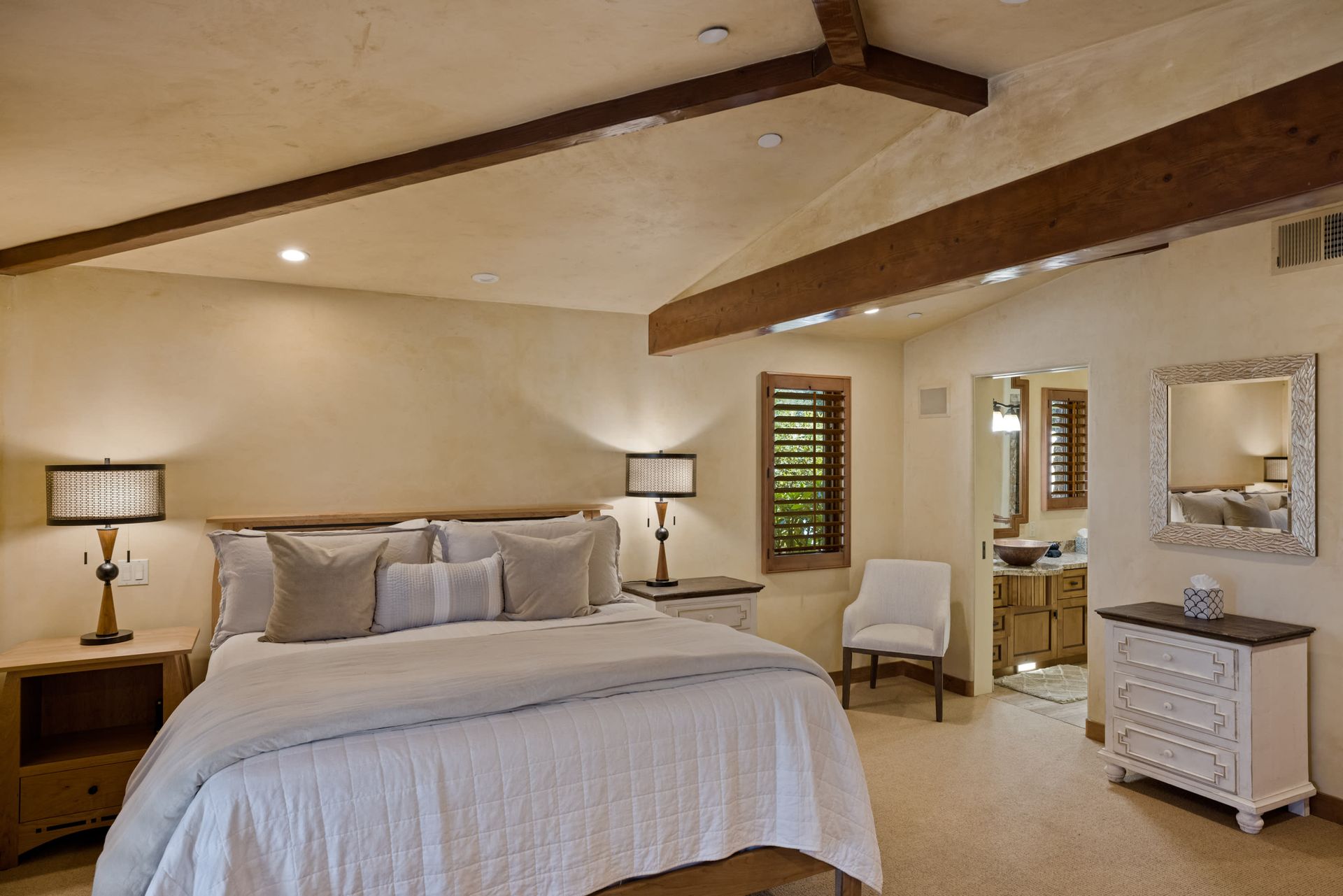 A bedroom with a large bed and a mirror