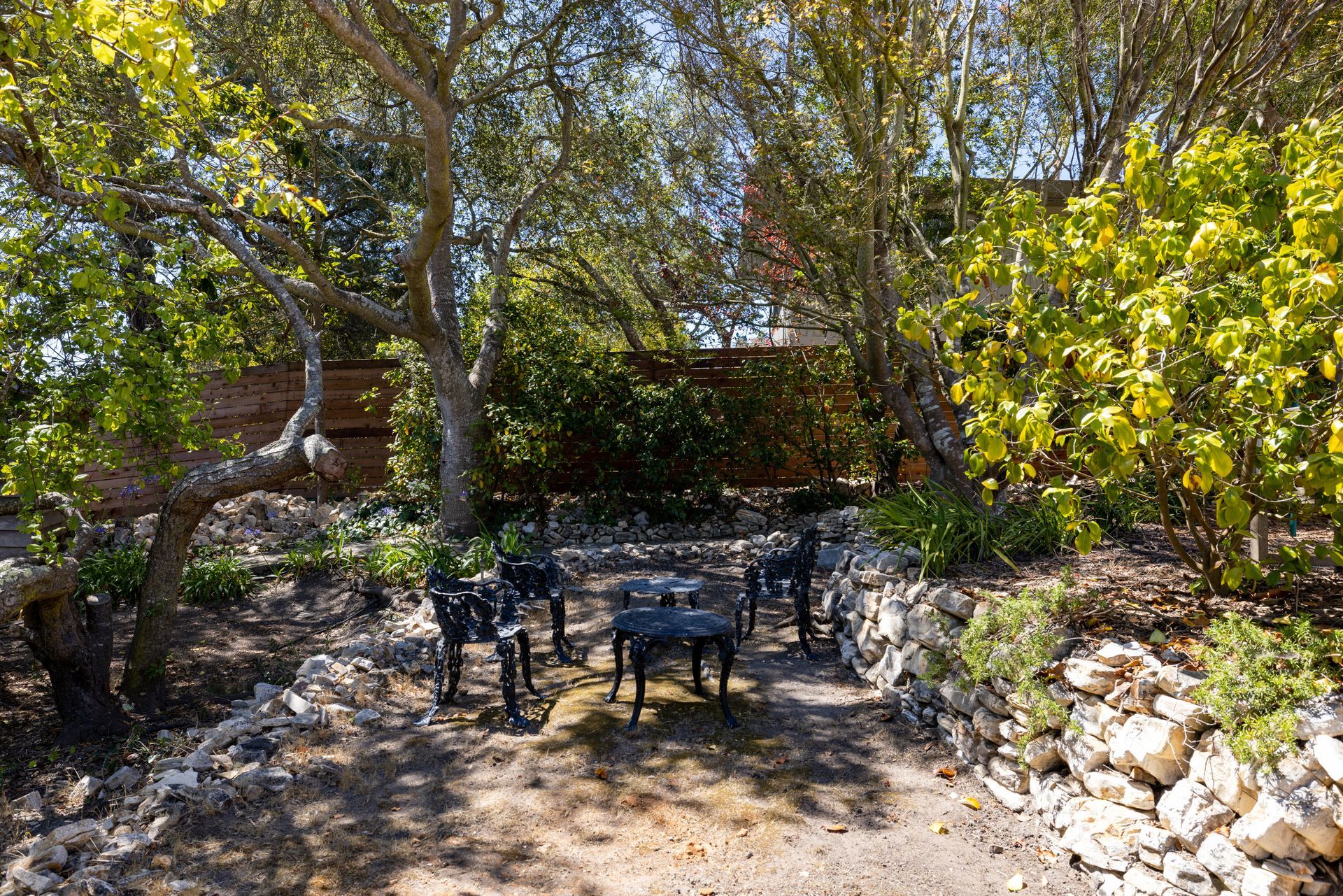 There is a table and chairs in the middle of the woods.