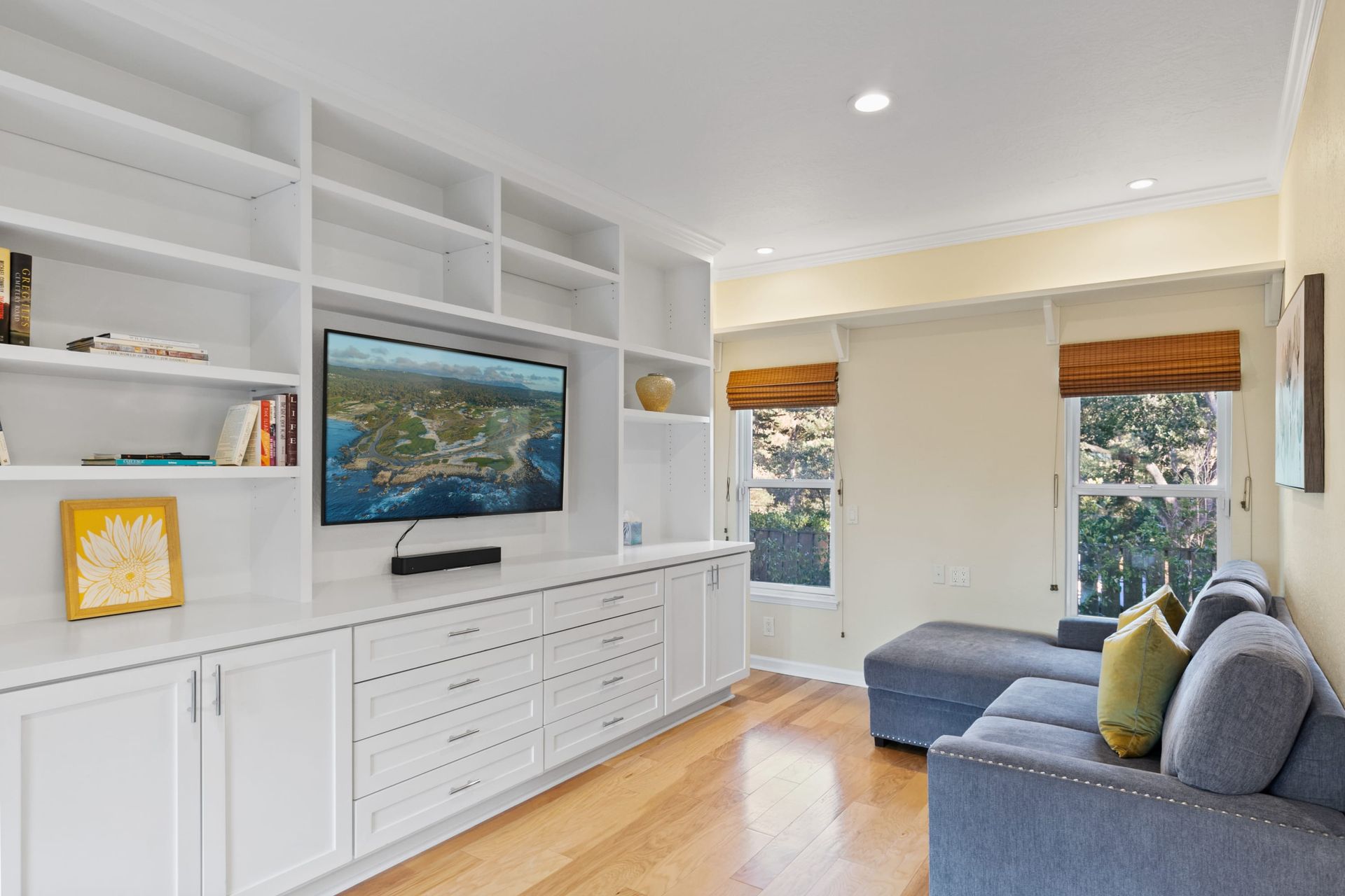 A living room with a couch , television , and shelves.