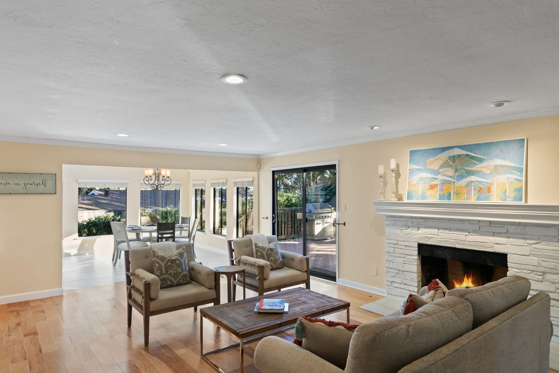 A living room with a couch , chairs , coffee table and fireplace.