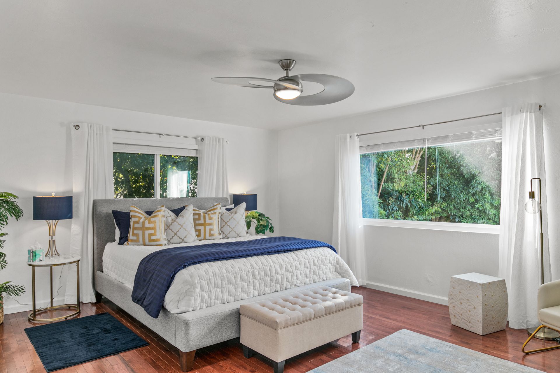 A bedroom with a large bed and a ceiling fan.