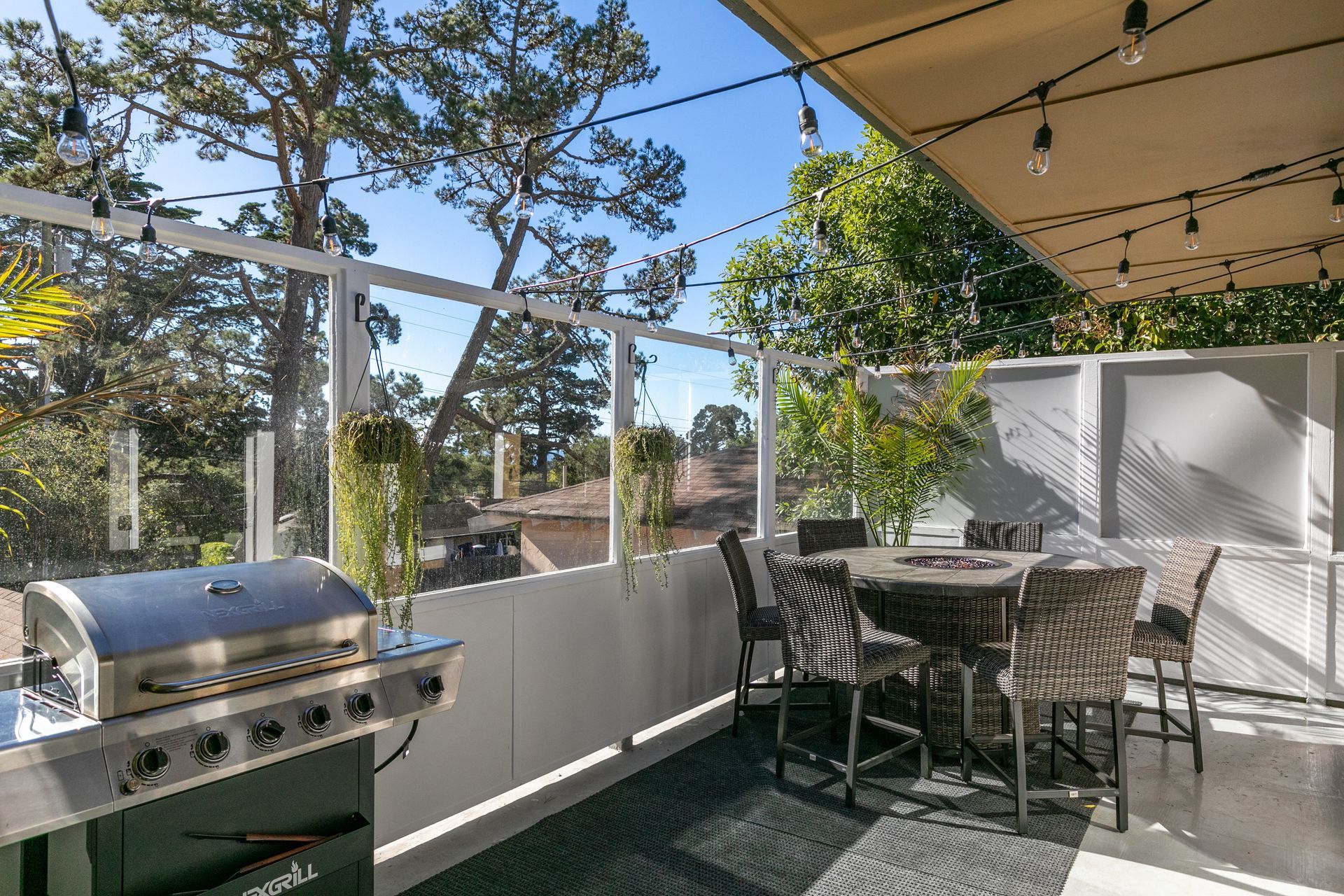 A patio with a table and chairs and a grill.
