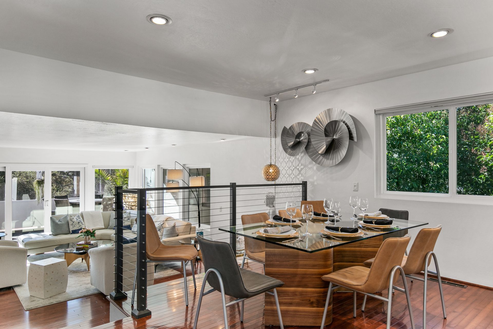 A dining room with a glass table and chairs in a house.