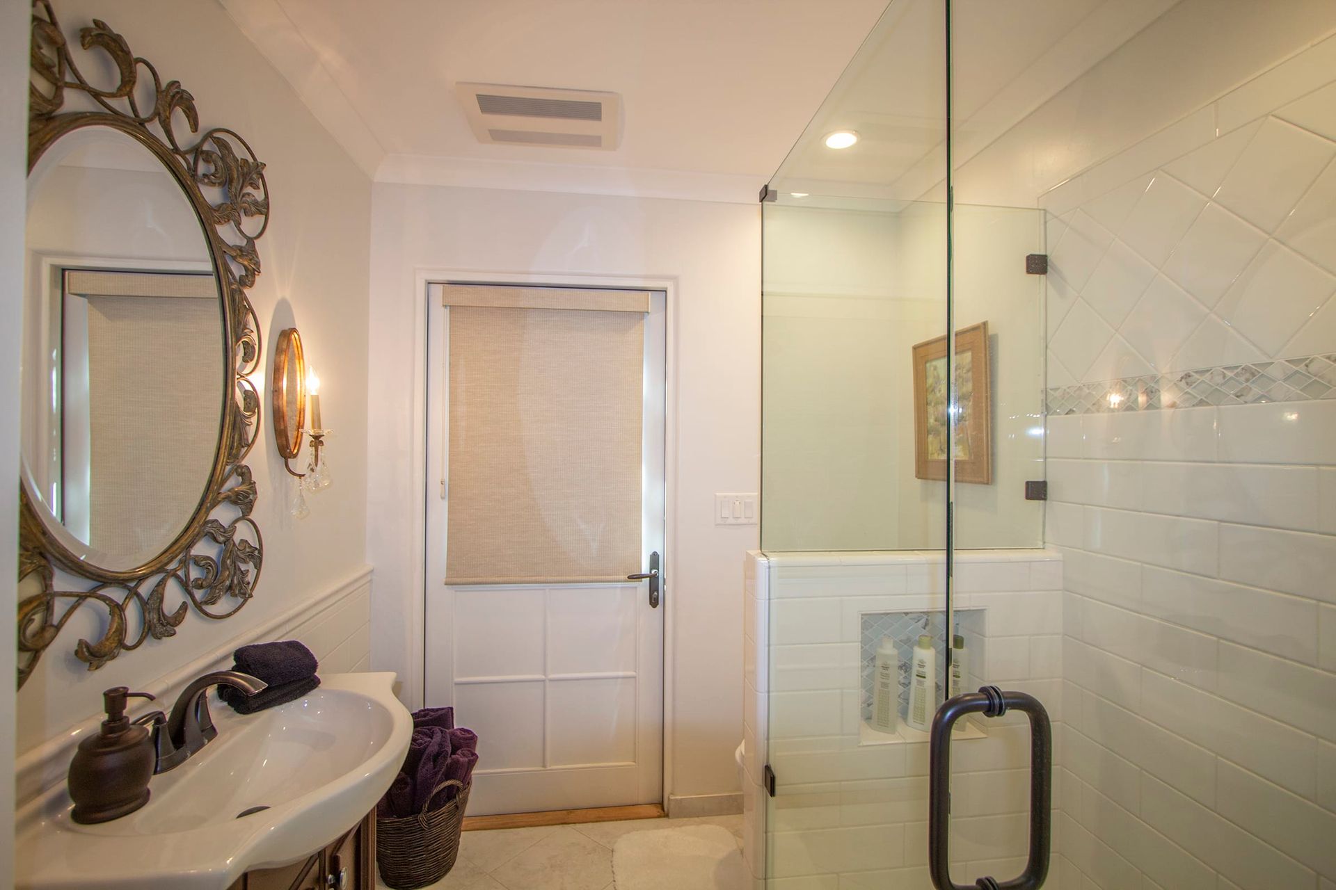 A bathroom with a sink , mirror , and walk in shower.