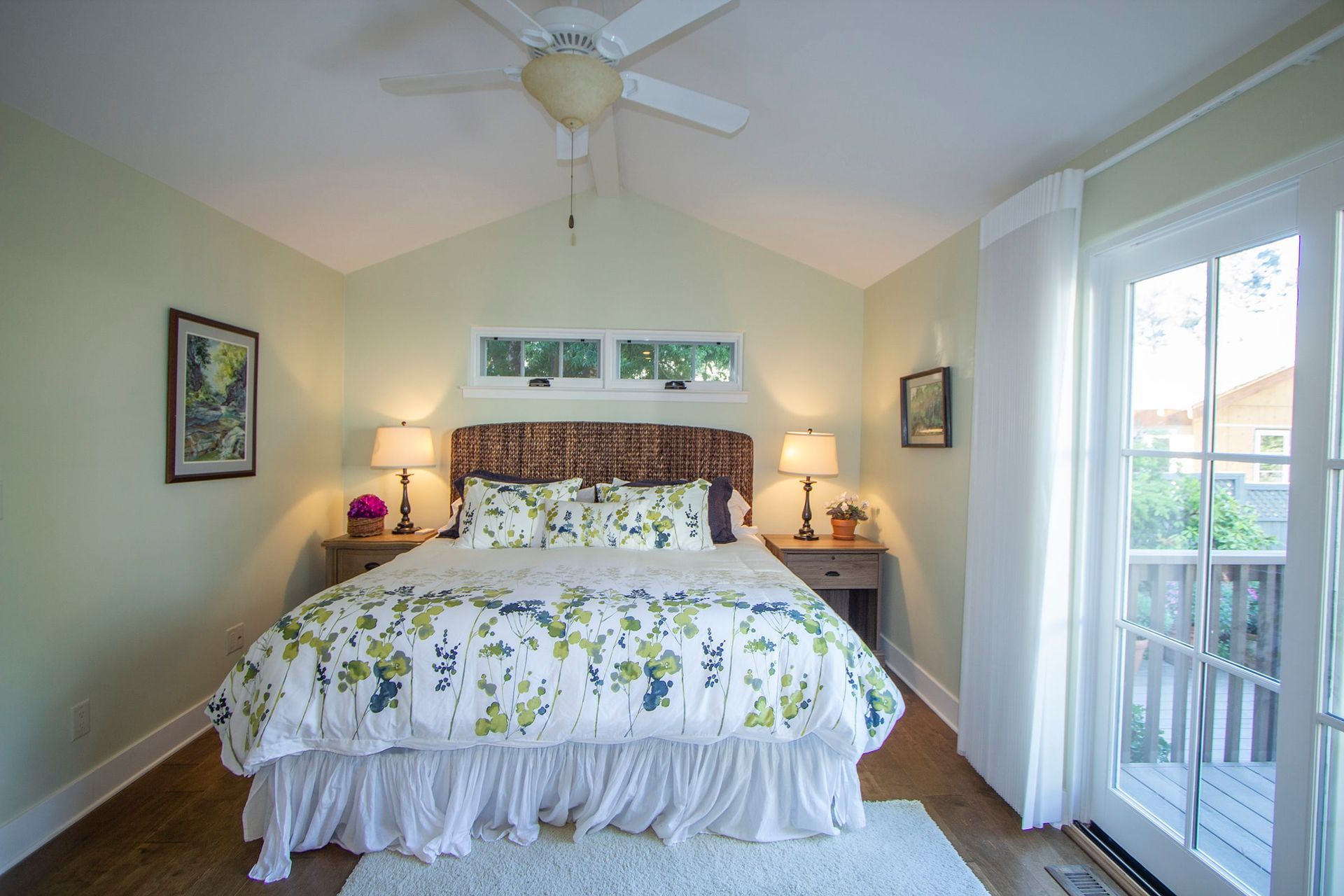 A bedroom with a king size bed and a ceiling fan.