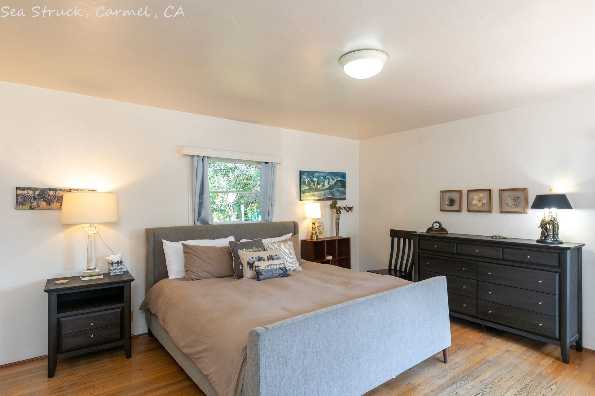 A bedroom with a bed , nightstand , dresser and chair.