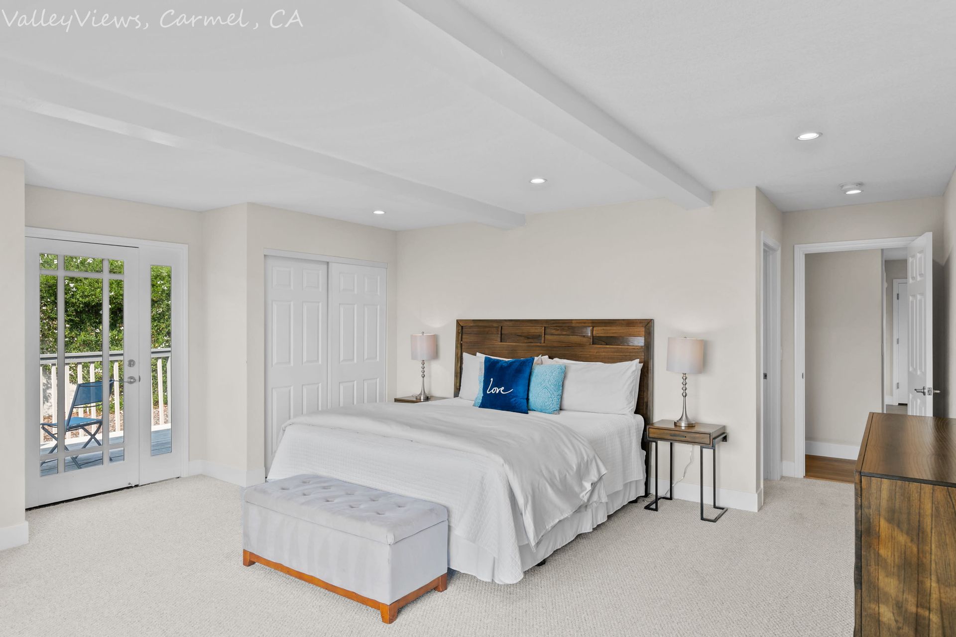 A bedroom with a large bed and a dresser