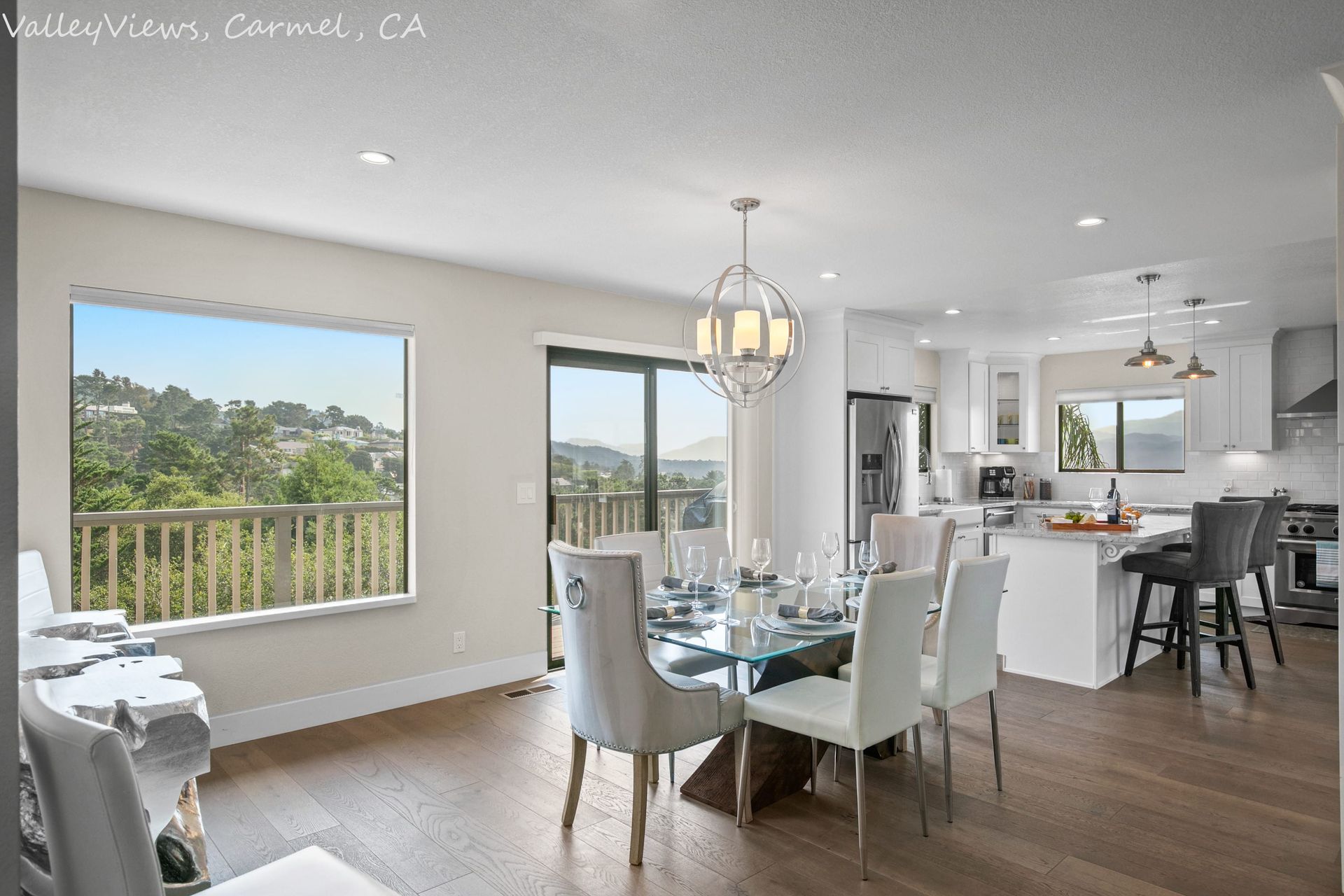 A dining room with a table and chairs and a large window