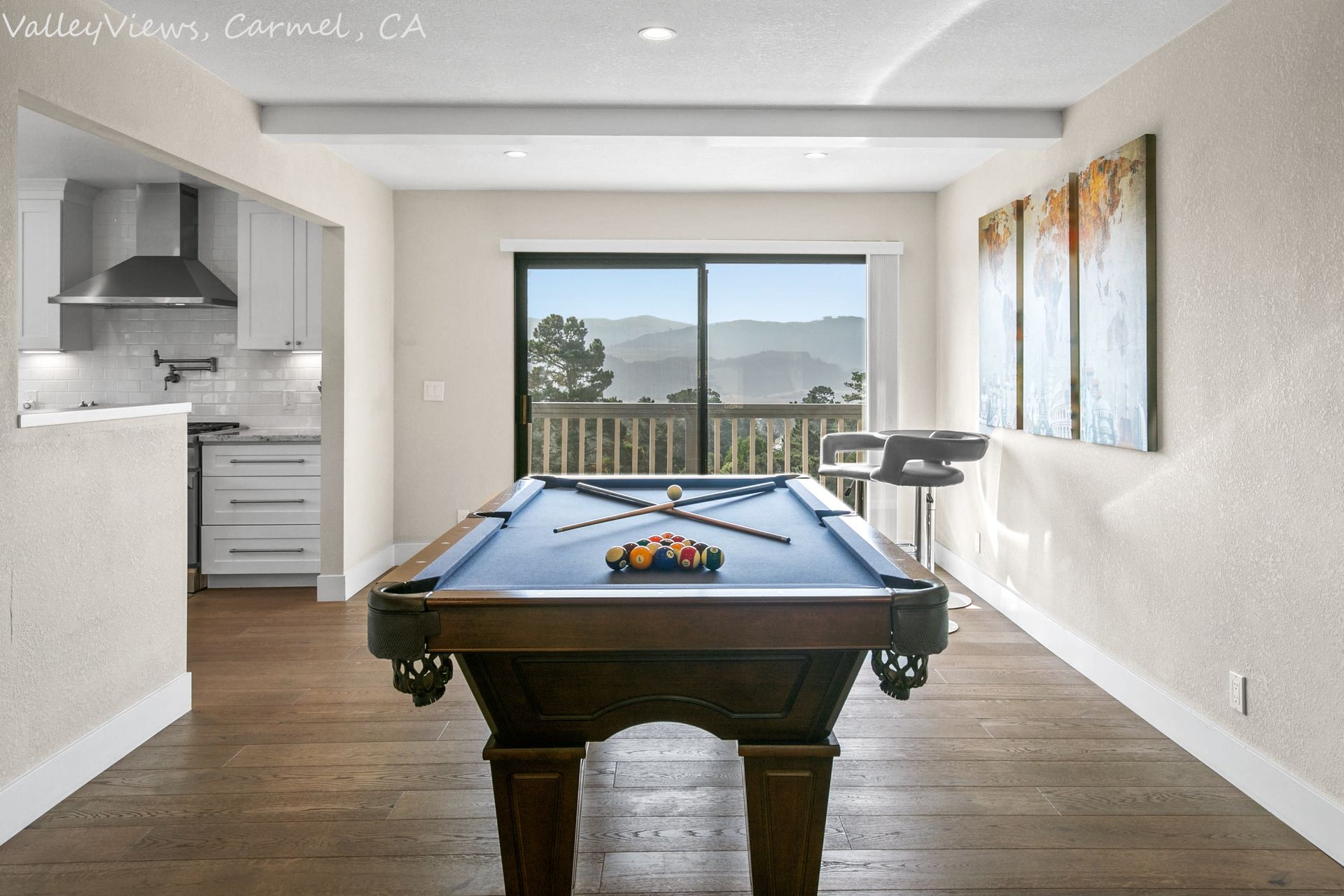 A pool table in a living room with a sliding glass door