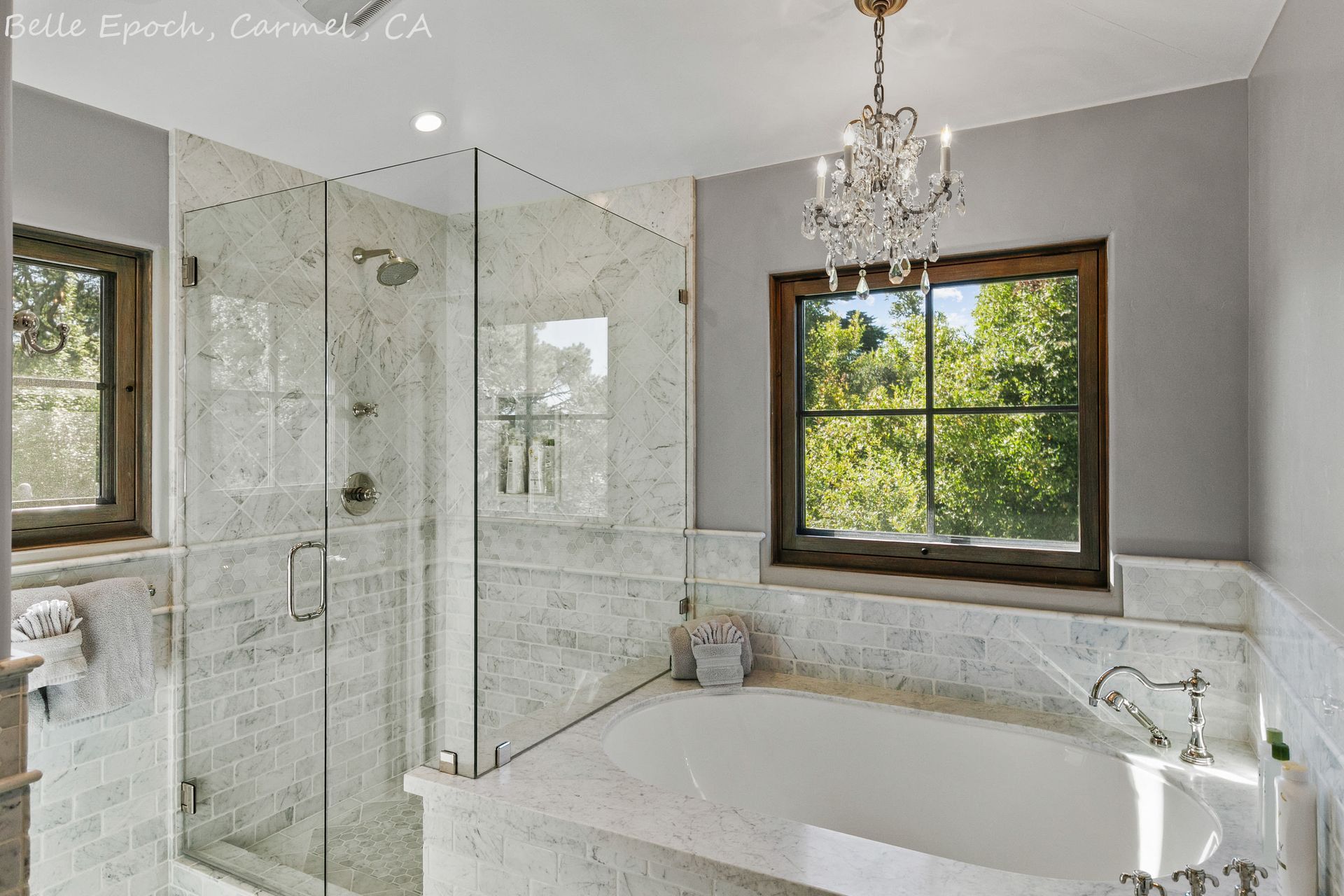 A bathroom with a tub , shower , and window