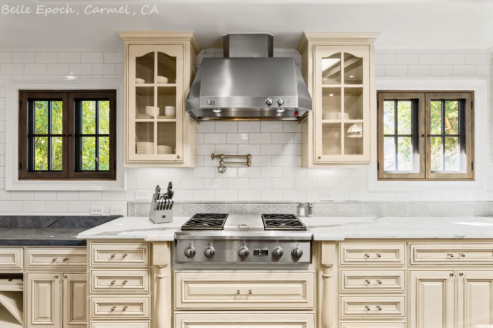 A kitchen with white cabinets and stainless steel appliances